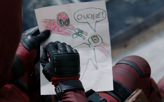 Deadpool holding a drawing of himself shooting someone