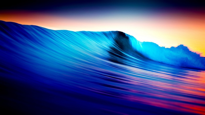 Long exposure of a colorful ocean wave at sunset