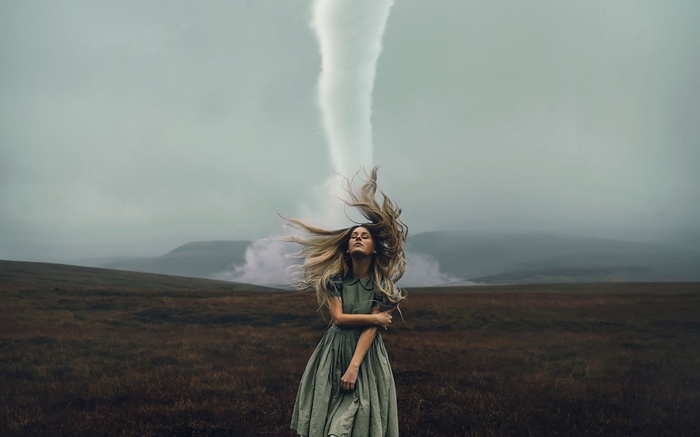 Woman with tornado in a field