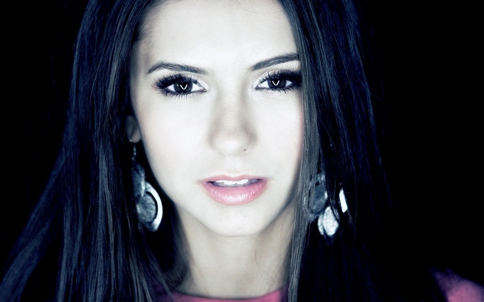 Nina Dobrev with long dark hair and large earrings