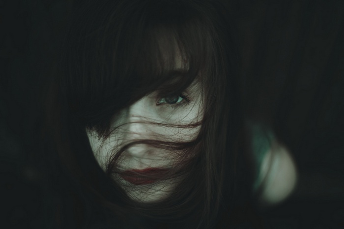 Woman with hair in face and red lipstick