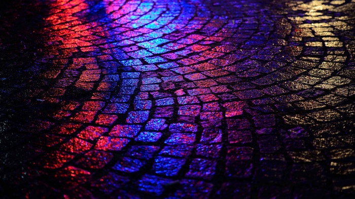 Wet cobblestone street with colorful reflections
