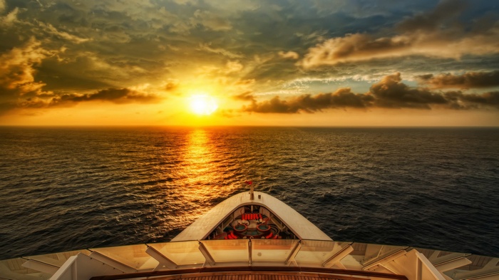 Cruise ship sailing into the sunset over the ocean