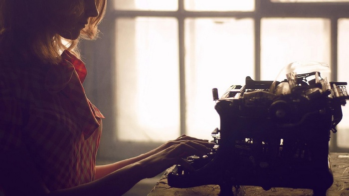Woman typing on a vintage typewriter