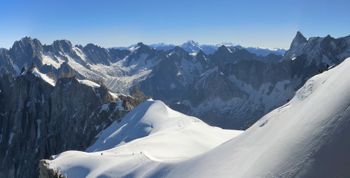 Panoramic view of snow-covered mountains under a clear blue sky