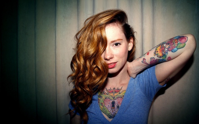 Hattie Watson with red curly hair and tattoos