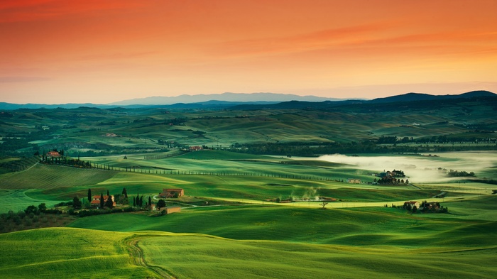 Rolling green hills of Tuscany at sunrise