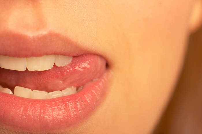 Close-up of a woman's mouth with tongue out