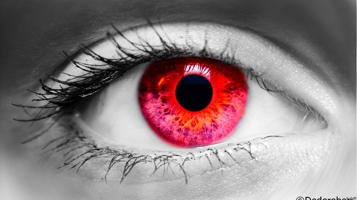 Close-up of a human eye with a red iris