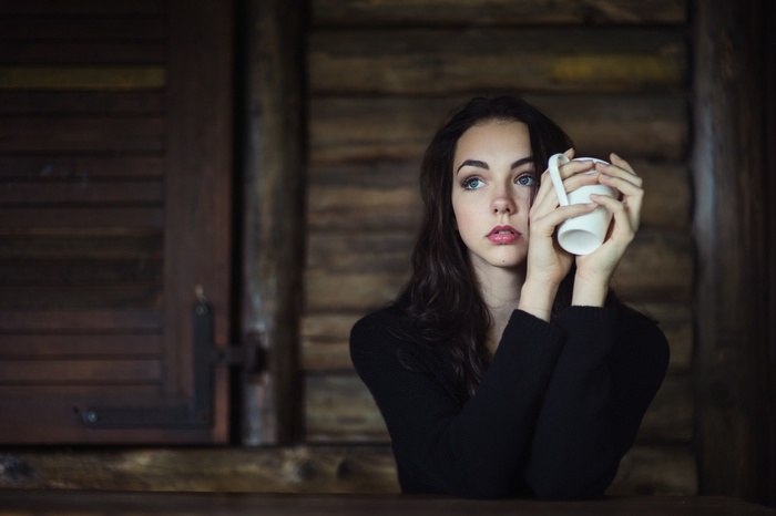 Woman with blue eyes holding a mug indoors