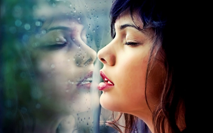 Woman looking out a rainy window