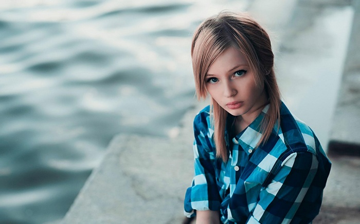 Woman in blue plaid shirt looking at viewer