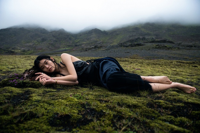 Ming Xi lying on mossy ground in Iceland