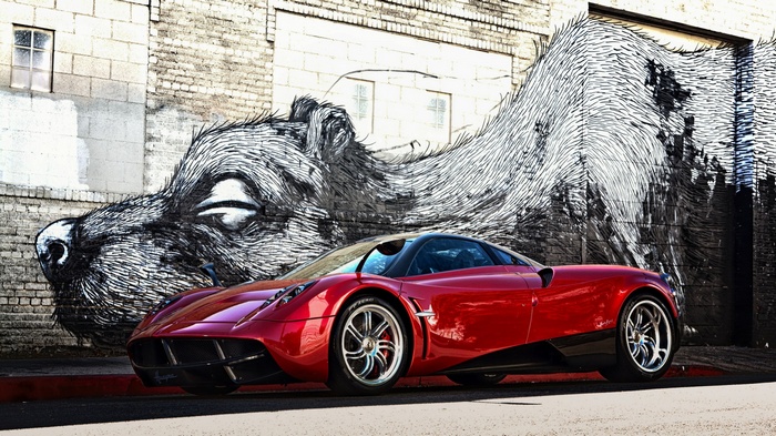Red Pagani Huayra parked in front of graffiti art