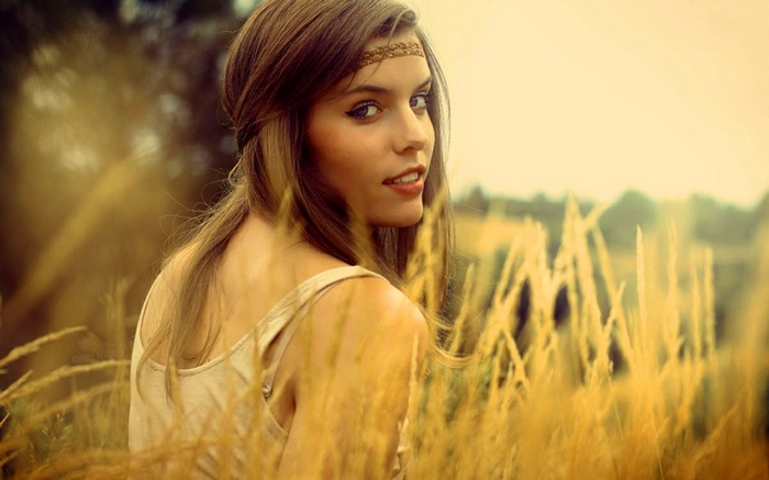 Woman with headband in a field of tall grass