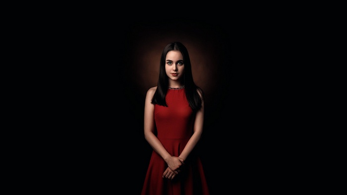 Woman in a red dress against a dark background