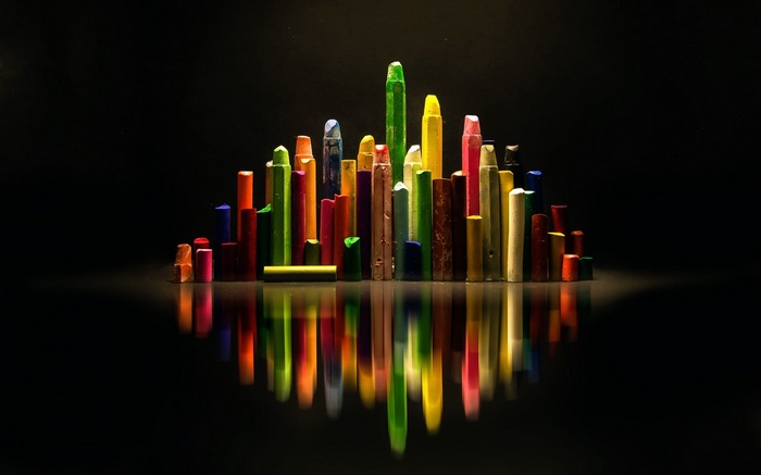 Colorful crayons arranged like a city skyline with reflections