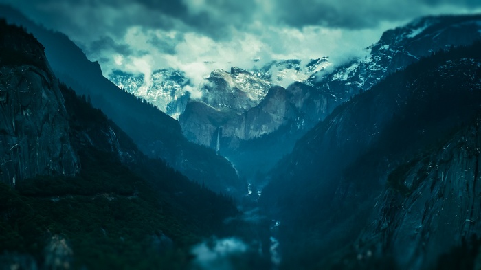 Misty mountains with a waterfall and clouds