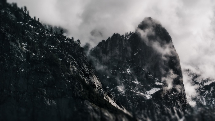 Misty mountains with rocky peaks and scattered trees