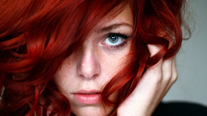 Close-up of a young woman with red hair and freckles