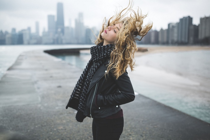 Woman with blonde hair in the wind by the water