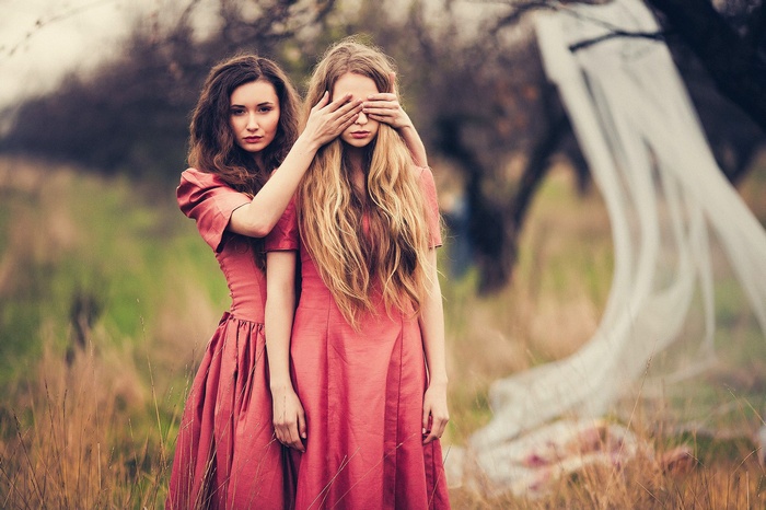 Two women in pink dresses in a field