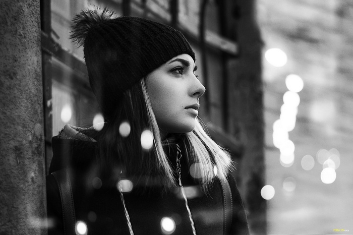 Woman in a beanie looking out a window