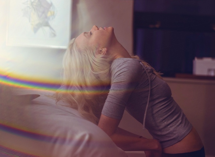 Woman with blonde hair leaning back with eyes closed