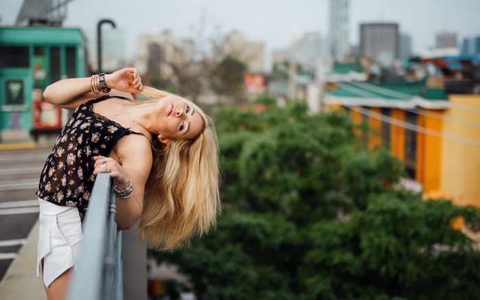 Woman with blonde hair leaning over a railing