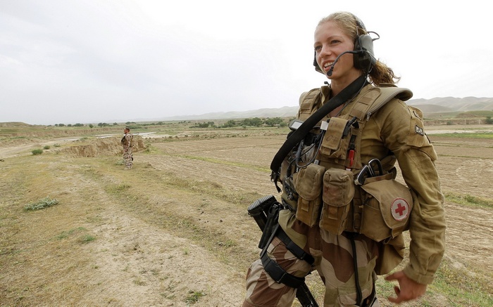 Female soldier with medical kit in arid landscape