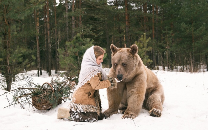 Girl and bear in a snowy forest