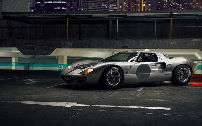 Silver Ford GT40 parked in a dimly lit parking garage