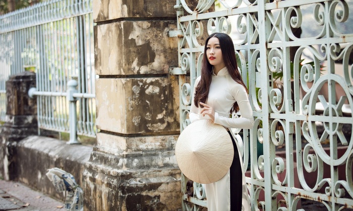Vietnamese woman in Ao Dai holding a Non La hat