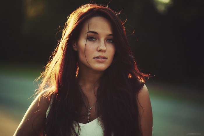 Young woman with long brown hair in sunlight