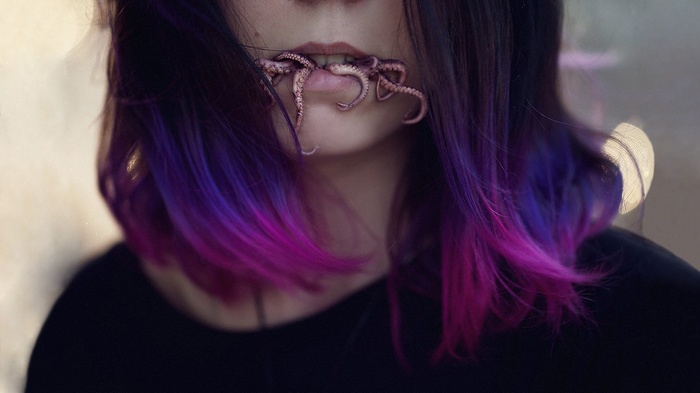 Woman with purple and blue hair and tentacles in mouth