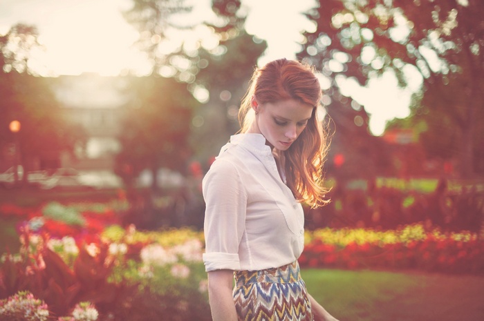 Redhead woman in a park at sunset