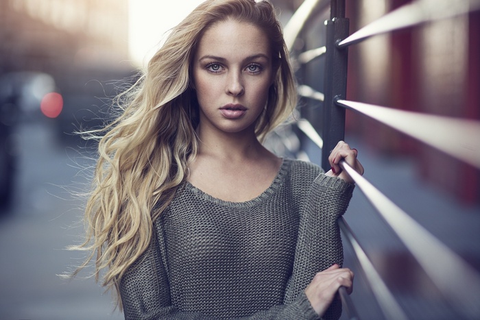 Woman with blonde hair and blue eyes wearing a sweater