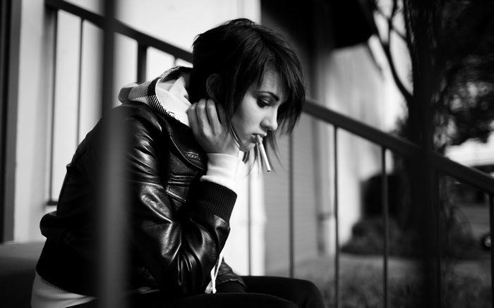 Woman sitting on steps smoking a cigarette