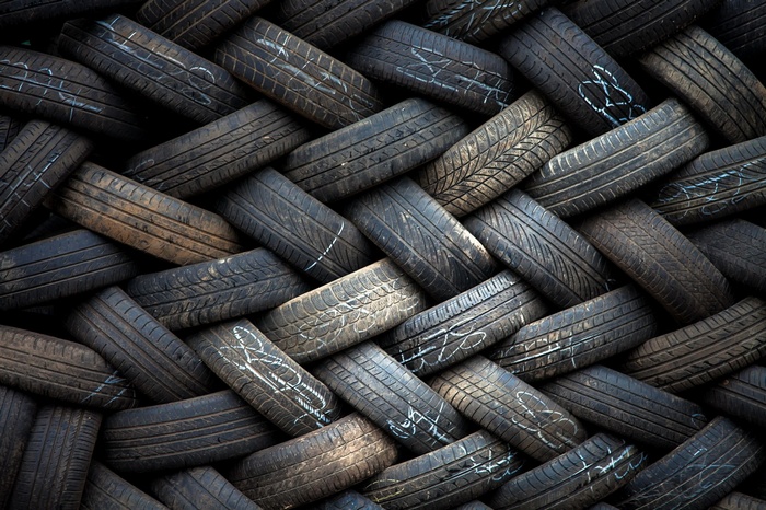 Pile of used black rubber tires with white markings