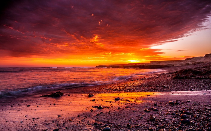 Sunset over a rocky beach with ocean waves