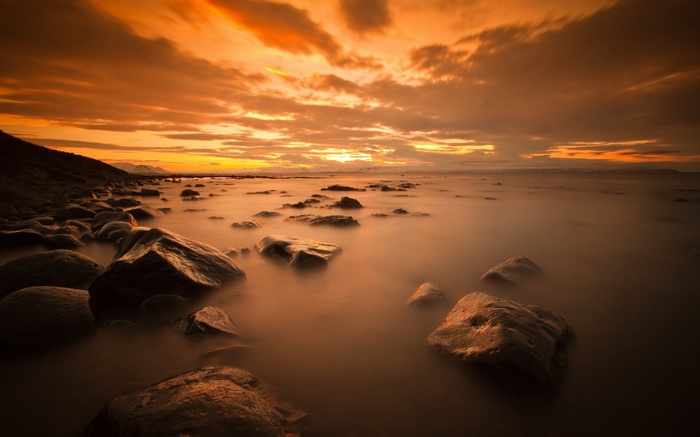 Rocky coast at sunset with orange sky