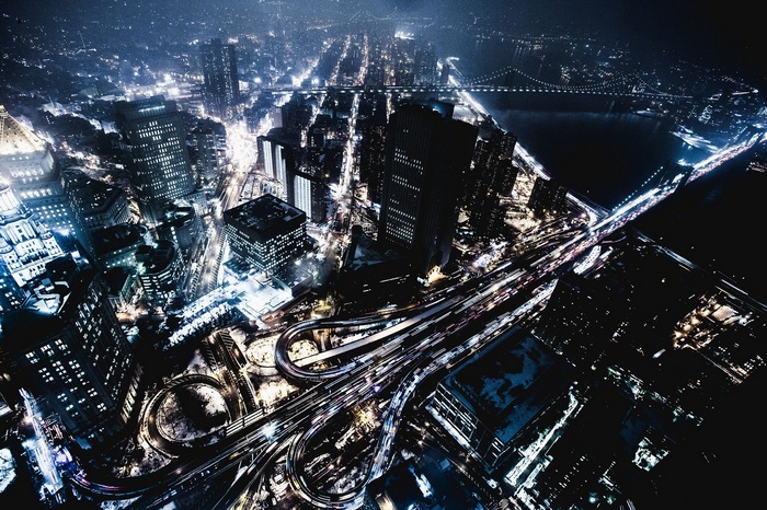 Aerial view of a city at night with highways and bridges