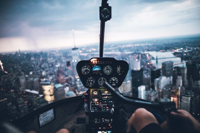 Helicopter cockpit overlooking New York City at dusk