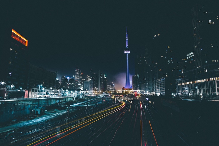 Toronto cityscape at night with CN Tower and light trails