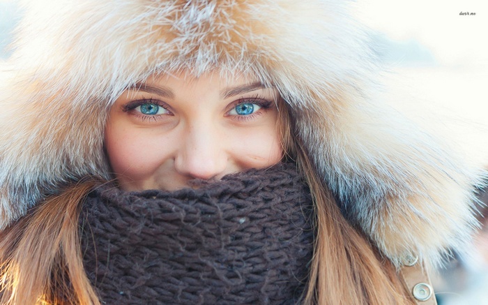 Woman with blue eyes wearing a fluffy hat and scarf
