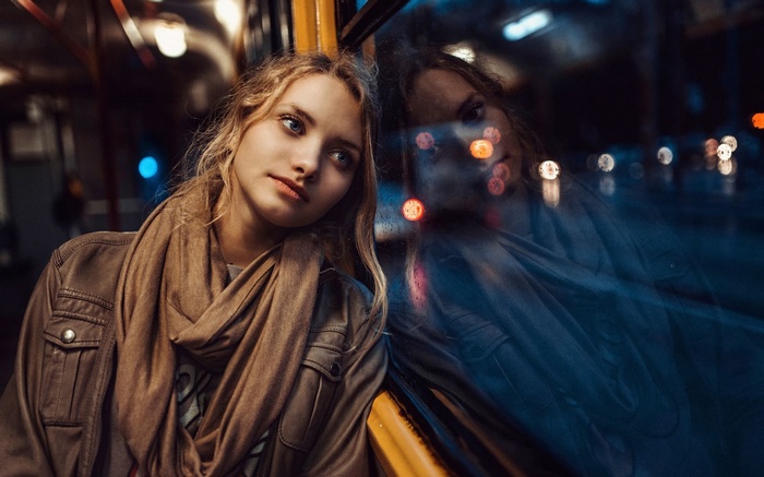 Woman with scarf leaning against window on vehicle