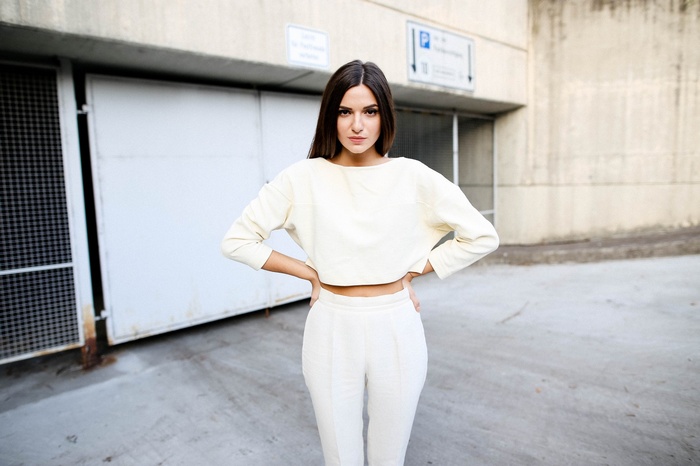 Woman in cream outfit with hands on hips