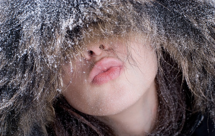 Woman with snow on her face and fur hood