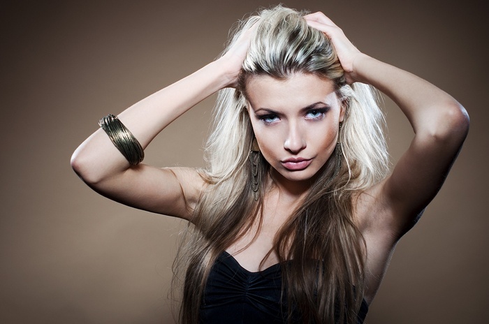 Woman with blonde hair and arms up