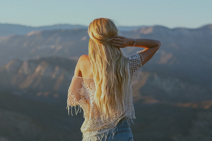 Woman with long blonde hair in mountains
